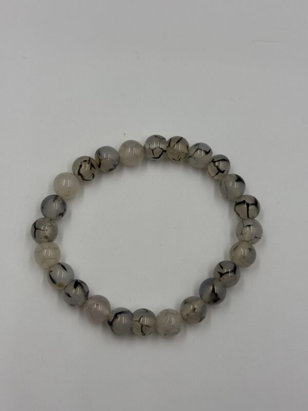 white Sulamini agate bracelet with 8mm polished beads on a silver-toned elastic cord.